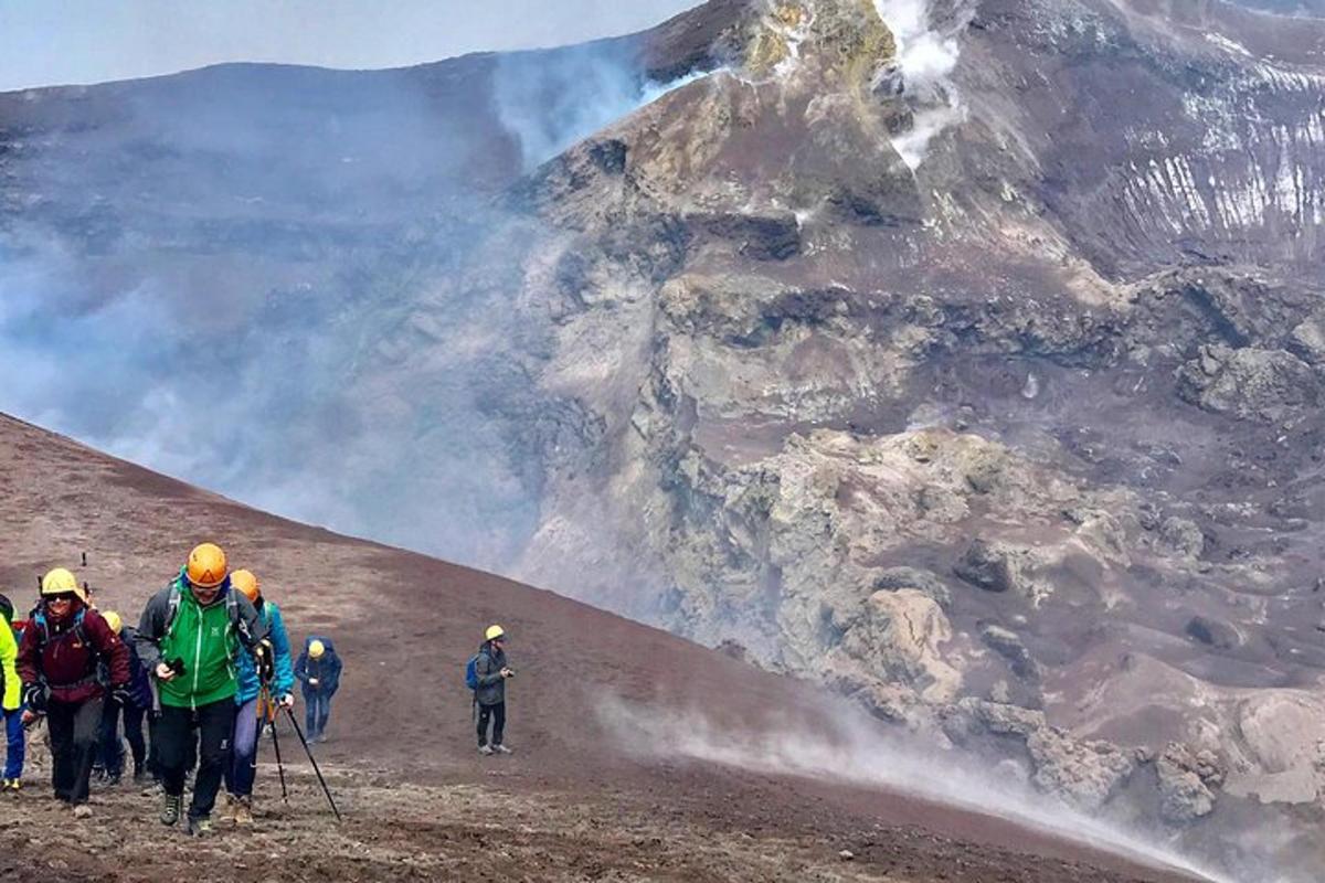hópur fólks gengur upp fjall með eldi