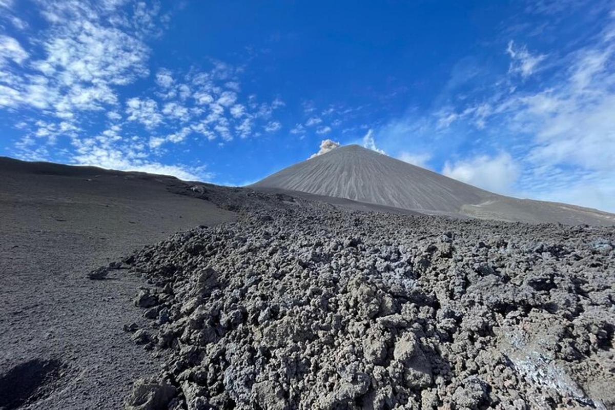 a mountain in the middle of a field with rocks