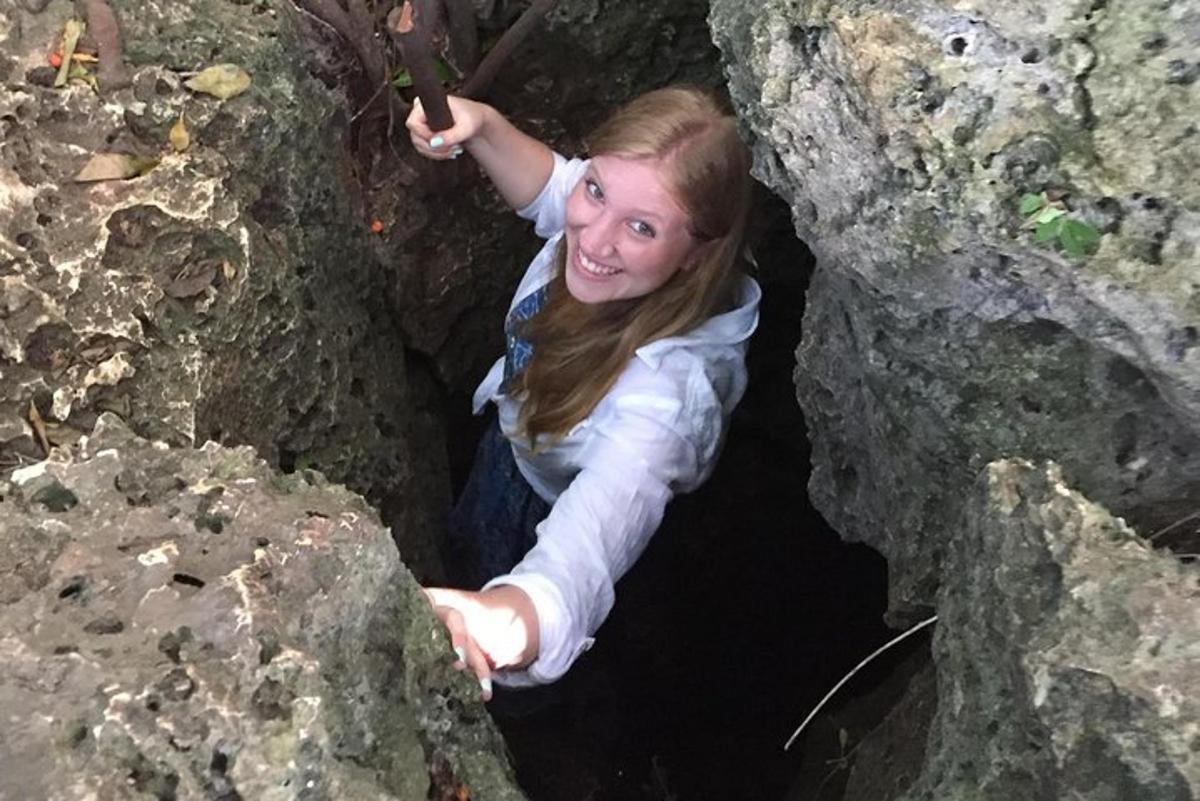 una giovane ragazza sta scalando una grotta rocciosa