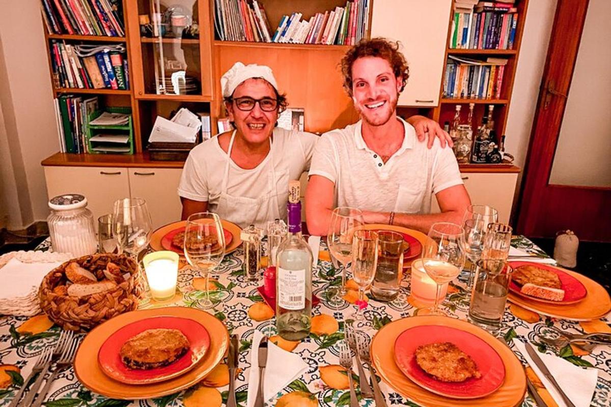 Dos hombres sentados en una mesa con platos de comida.
