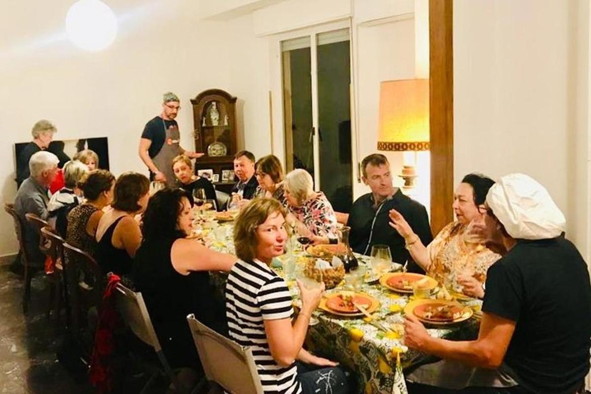 μια ομάδα ανθρώπων που κάθονται γύρω από ένα τραπέζι και τρώνε