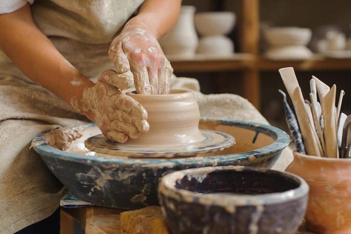 een vrouw die een pot maakt op een pottenbakkerswiel