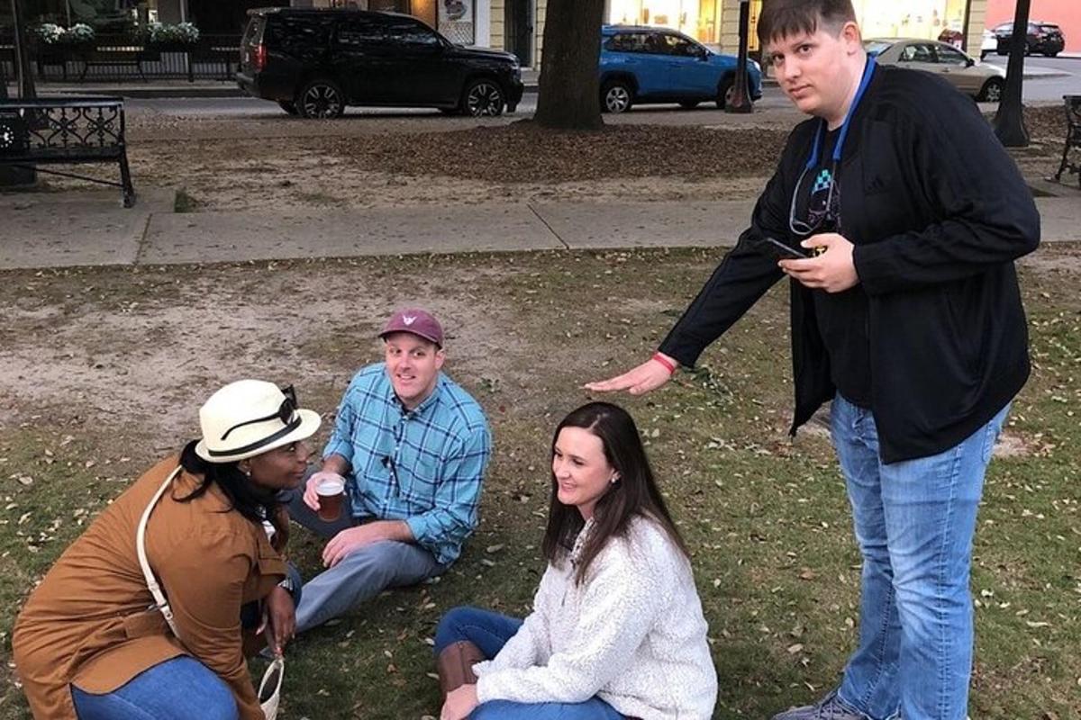 skupina lidí sedících na trávě v parku