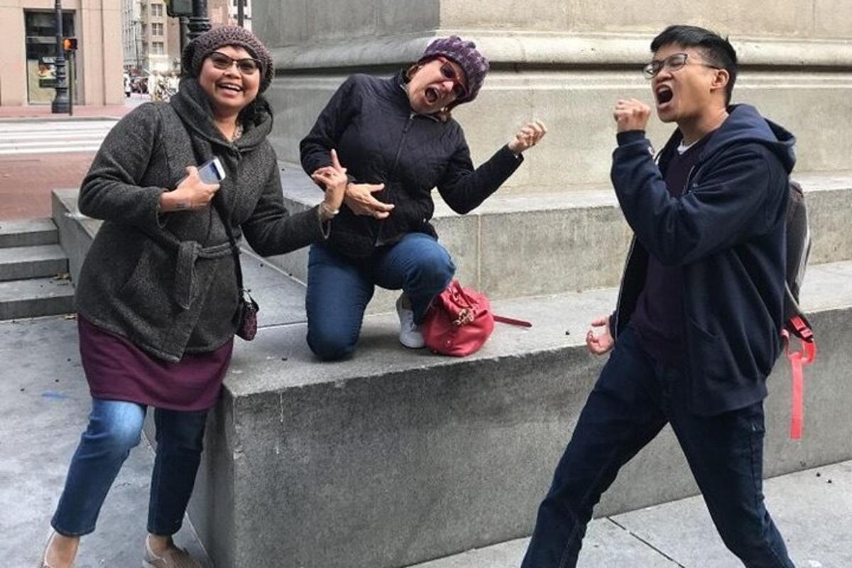 a group of three people sitting on a concrete ledge