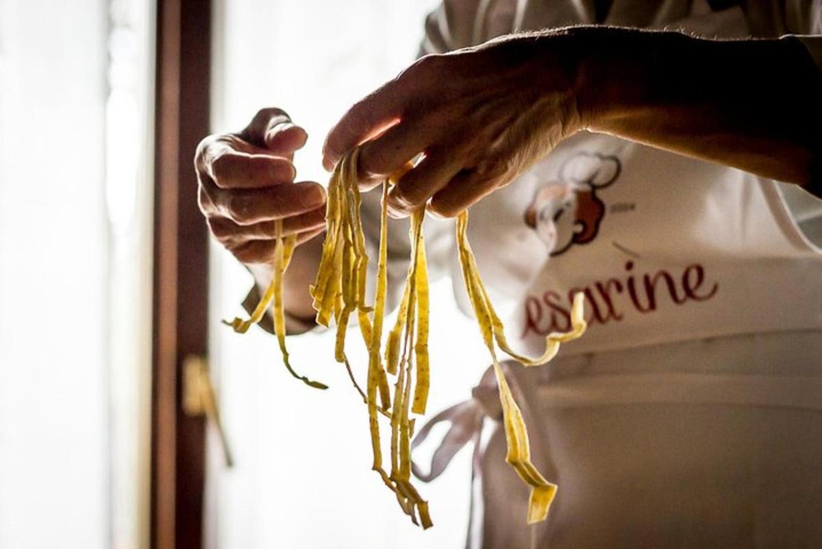 a hand holding a bunch of yellow pasta