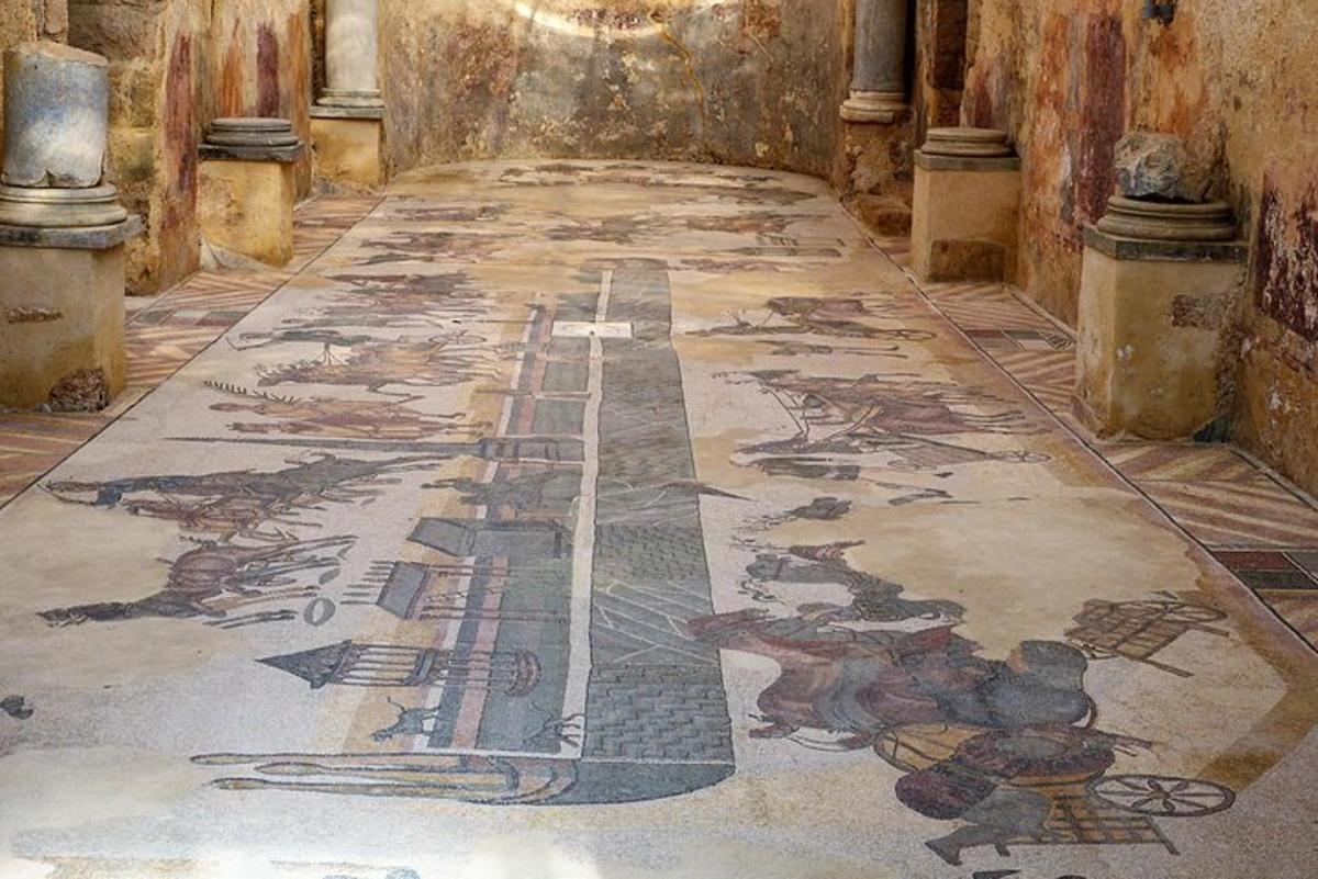 una stanza con un pavimento a mosaico in un edificio con un dipinto sopra