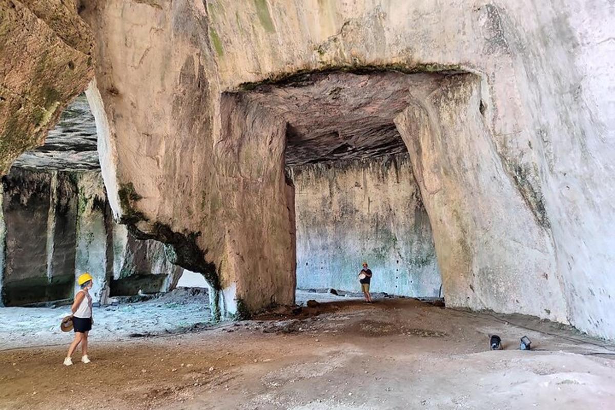 δύο άνθρωποι στέκονται μπροστά σε μια σπηλιά σε βράχο