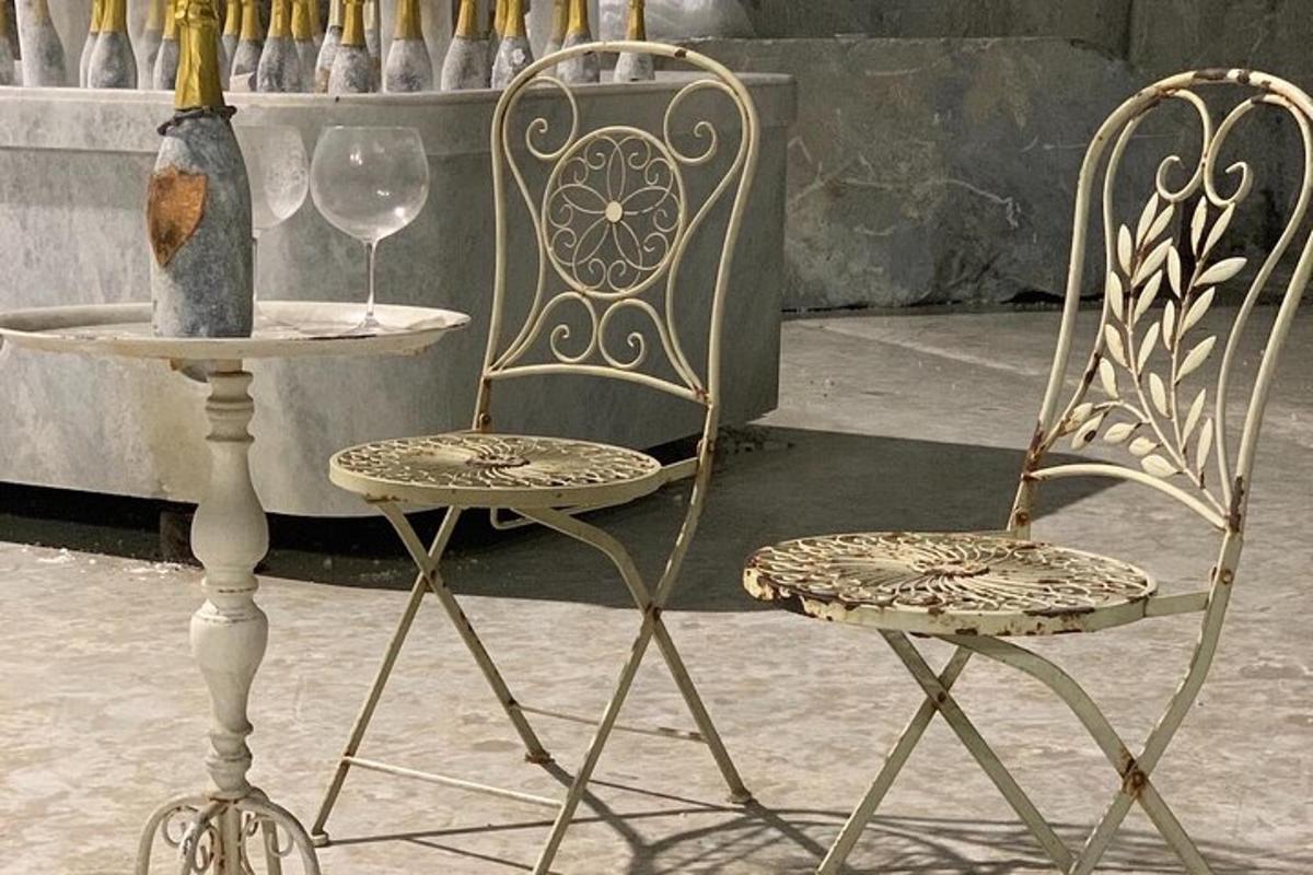 two chairs and a table with a bottle and a vase