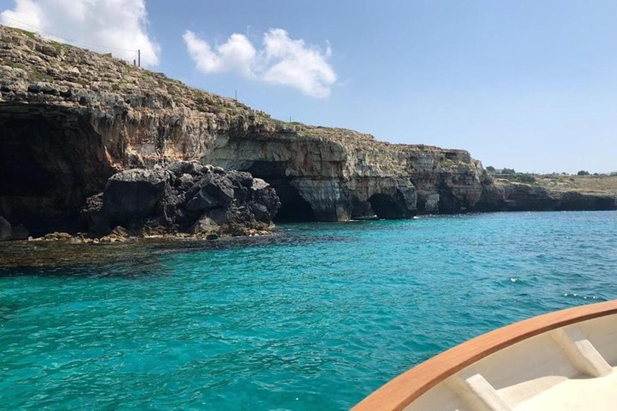 a boat in the water next to a cliff