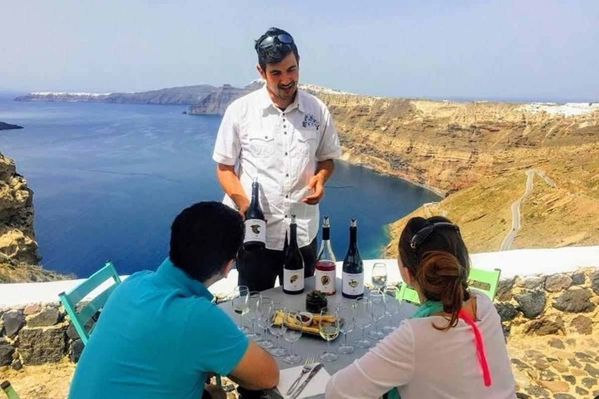 Ένας άντρας στέκεται δίπλα σε ένα τραπέζι με μπουκάλια κρασί