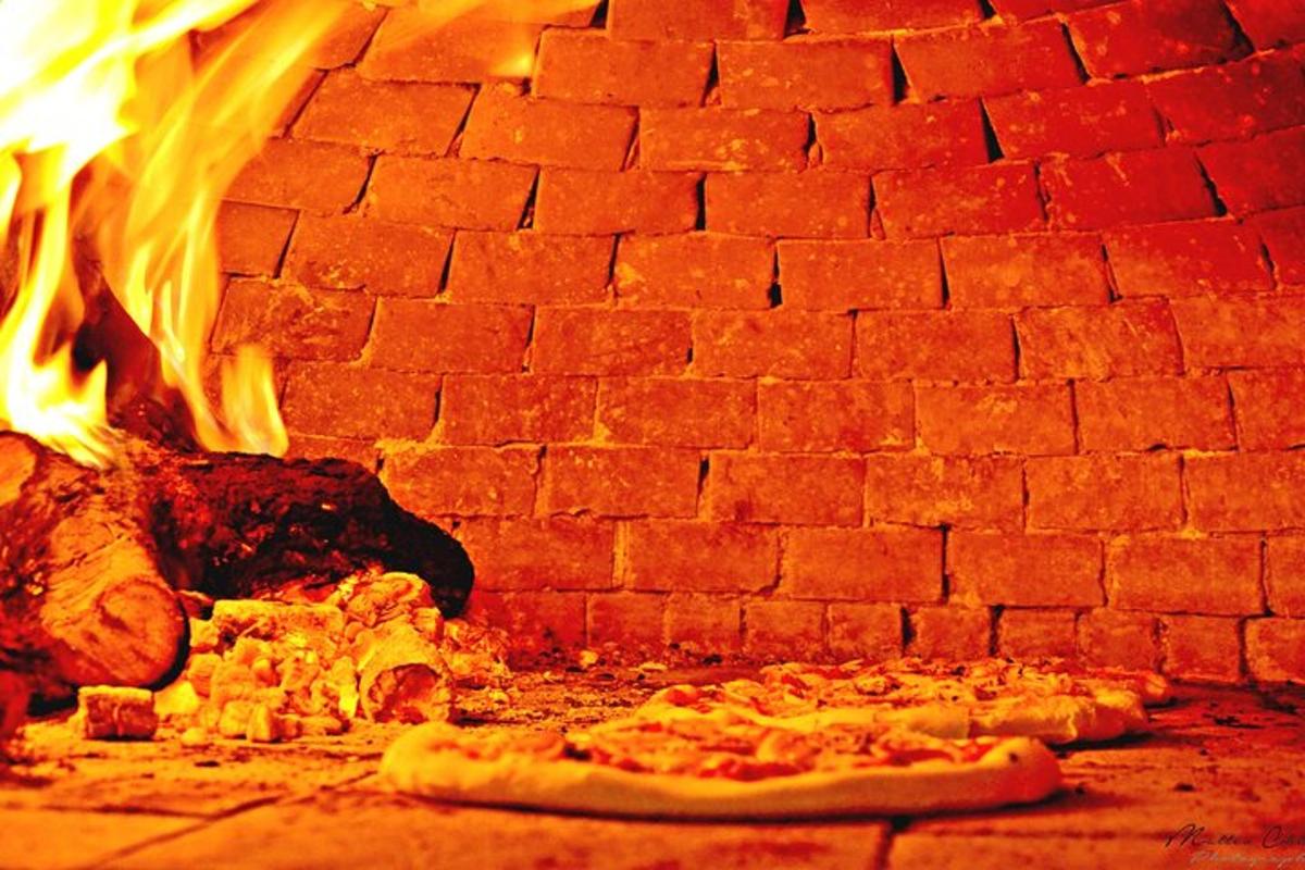 pizza sedang dimasak dalam ketuhar bata