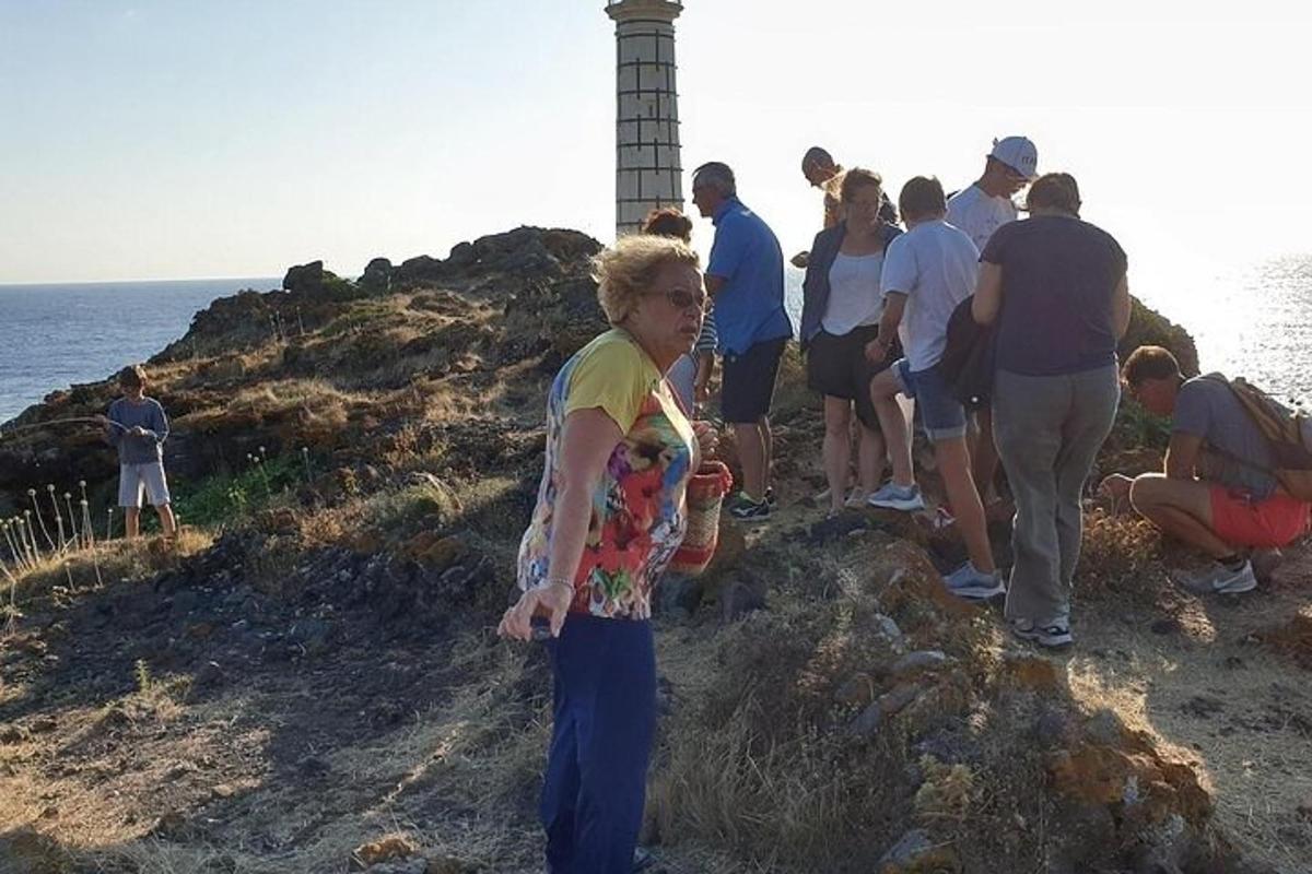 un gruppo di persone in piedi sul bordo di un faro