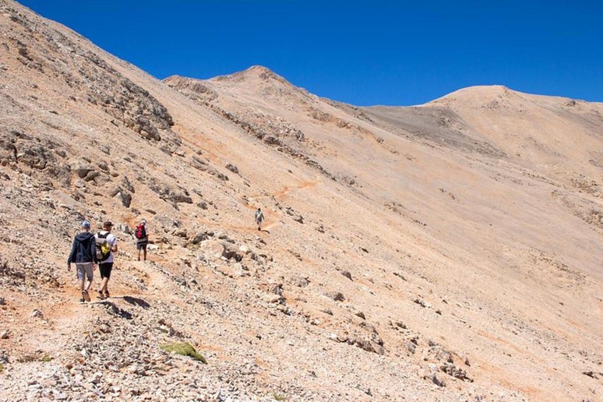 un gruppo di persone che cammina su una montagna rocciosa