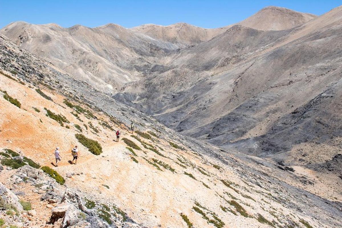due persone che camminano su una montagna che domina una valle
