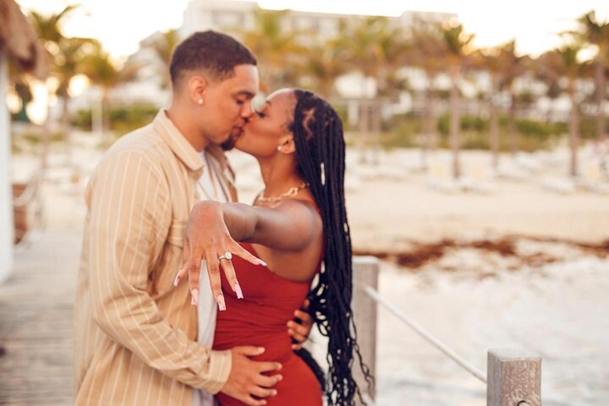 a man and a woman kissing on the beach