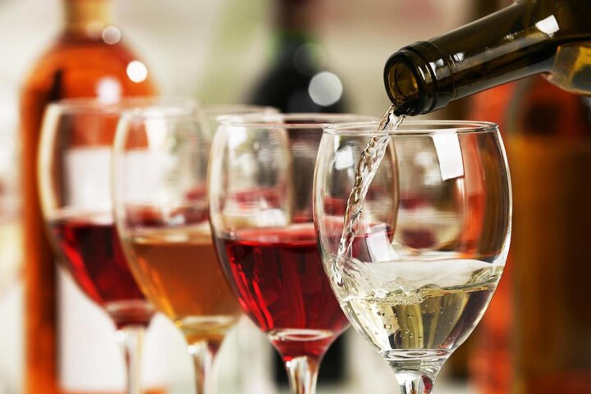 quattro bicchieri da vino in cui viene versato il vino
