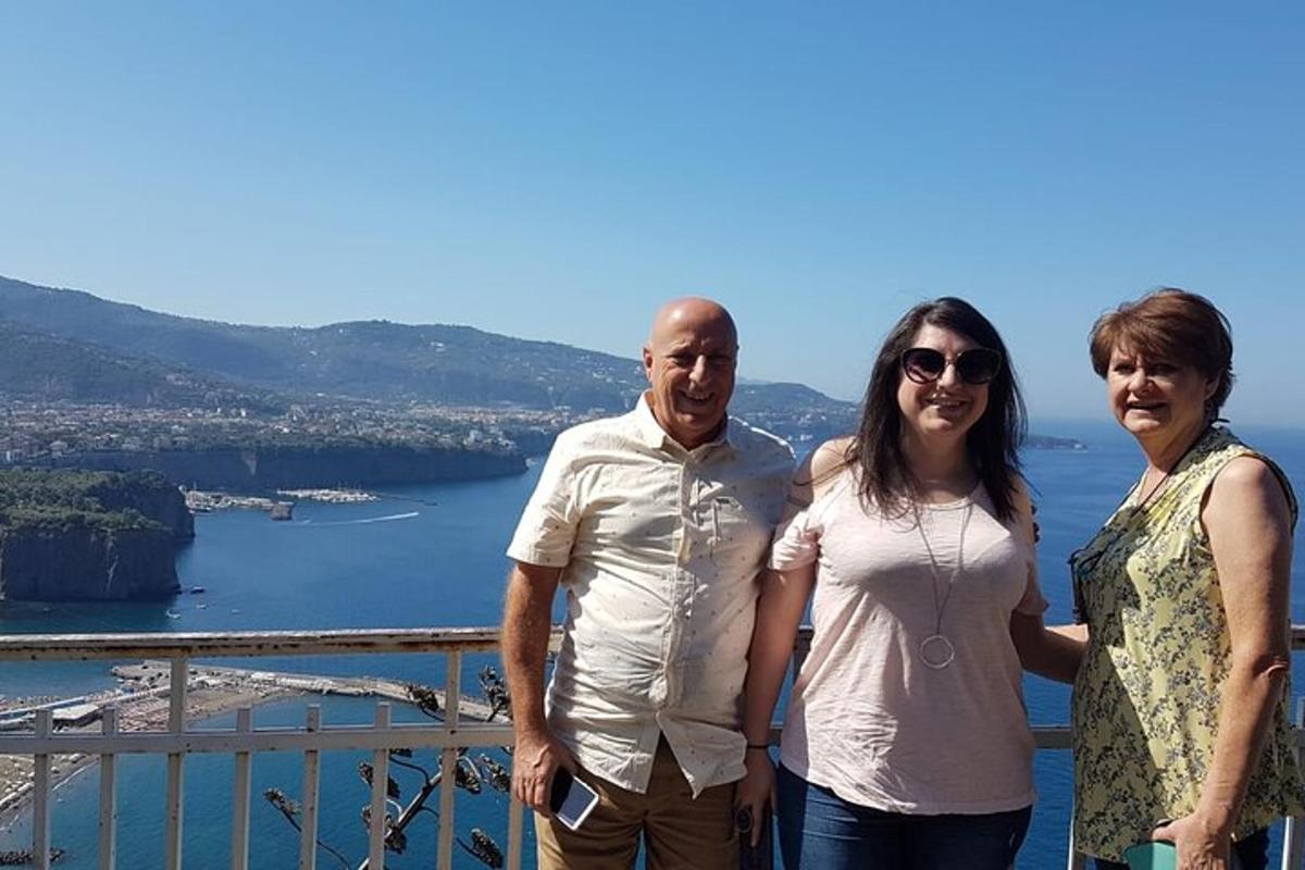 a man and two women standing on top of a balcony