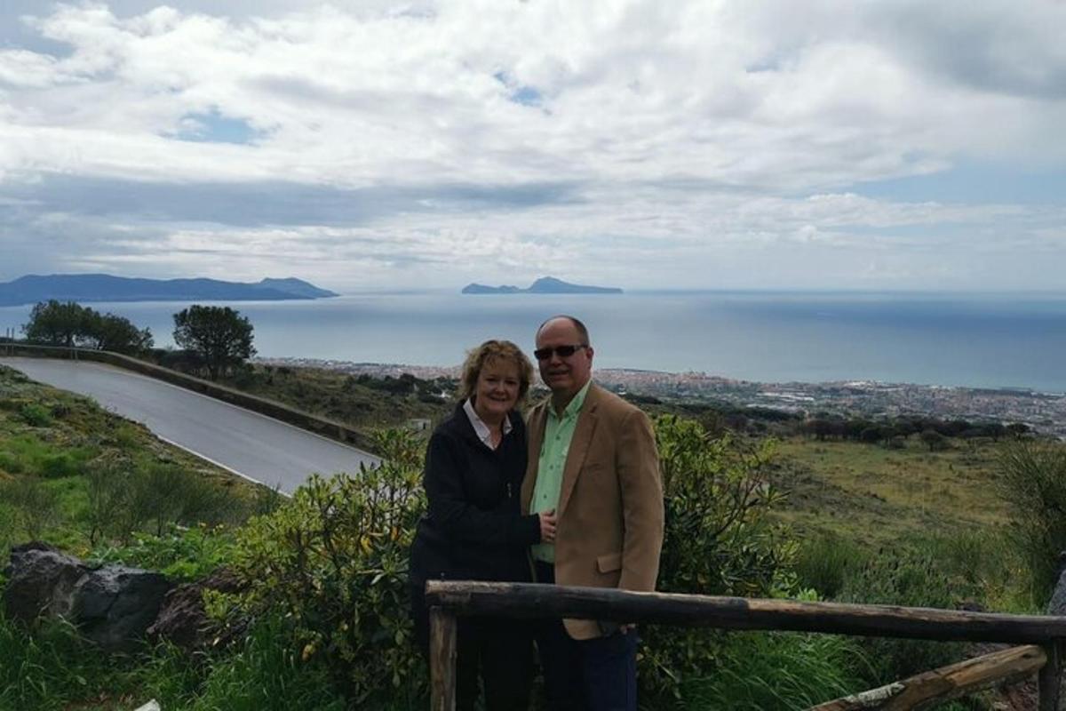 un uomo e una donna in piedi sulla cima di una collina