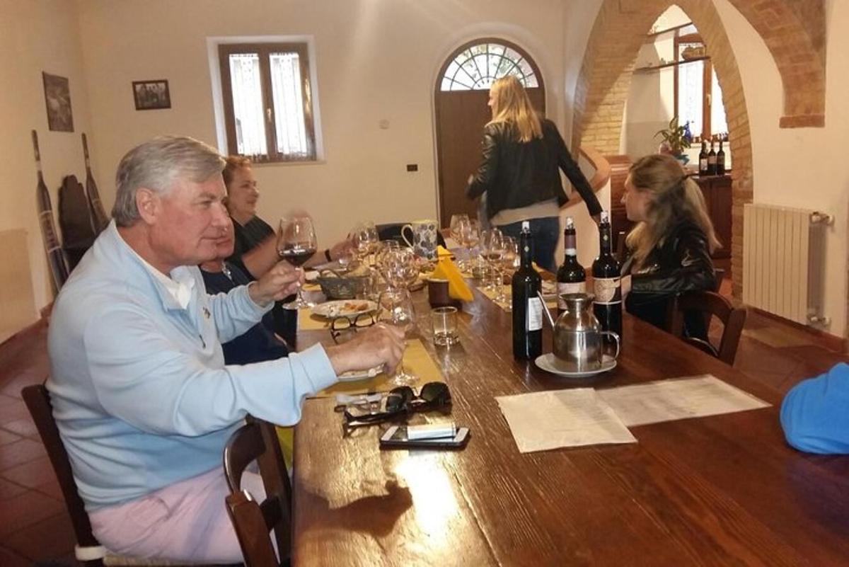 um grupo de pessoas sentadas à mesa com taças de vinho