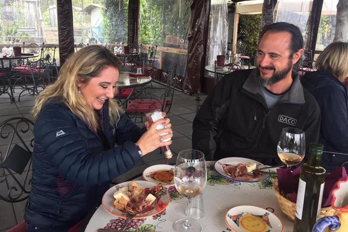un uomo e una donna seduti a un tavolo che mangiano cibo