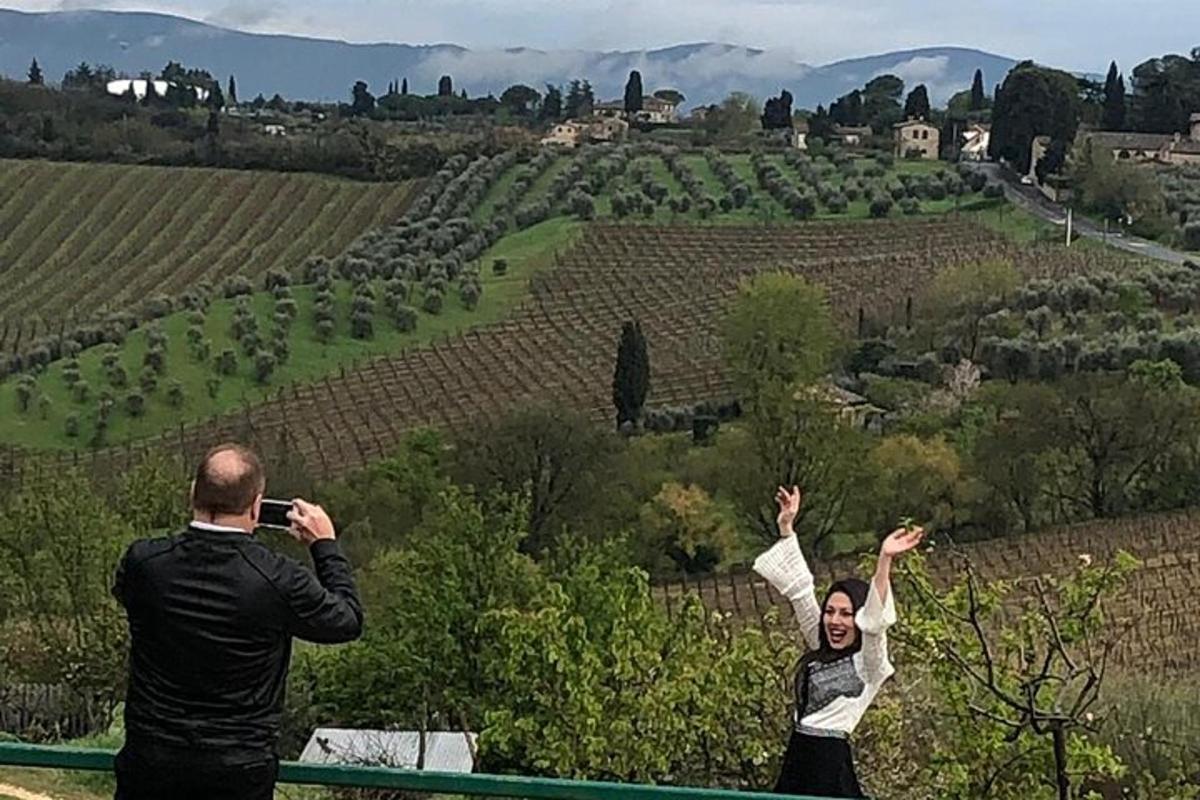 dues persones fent fotos d'una vinya amb les mans enlaire