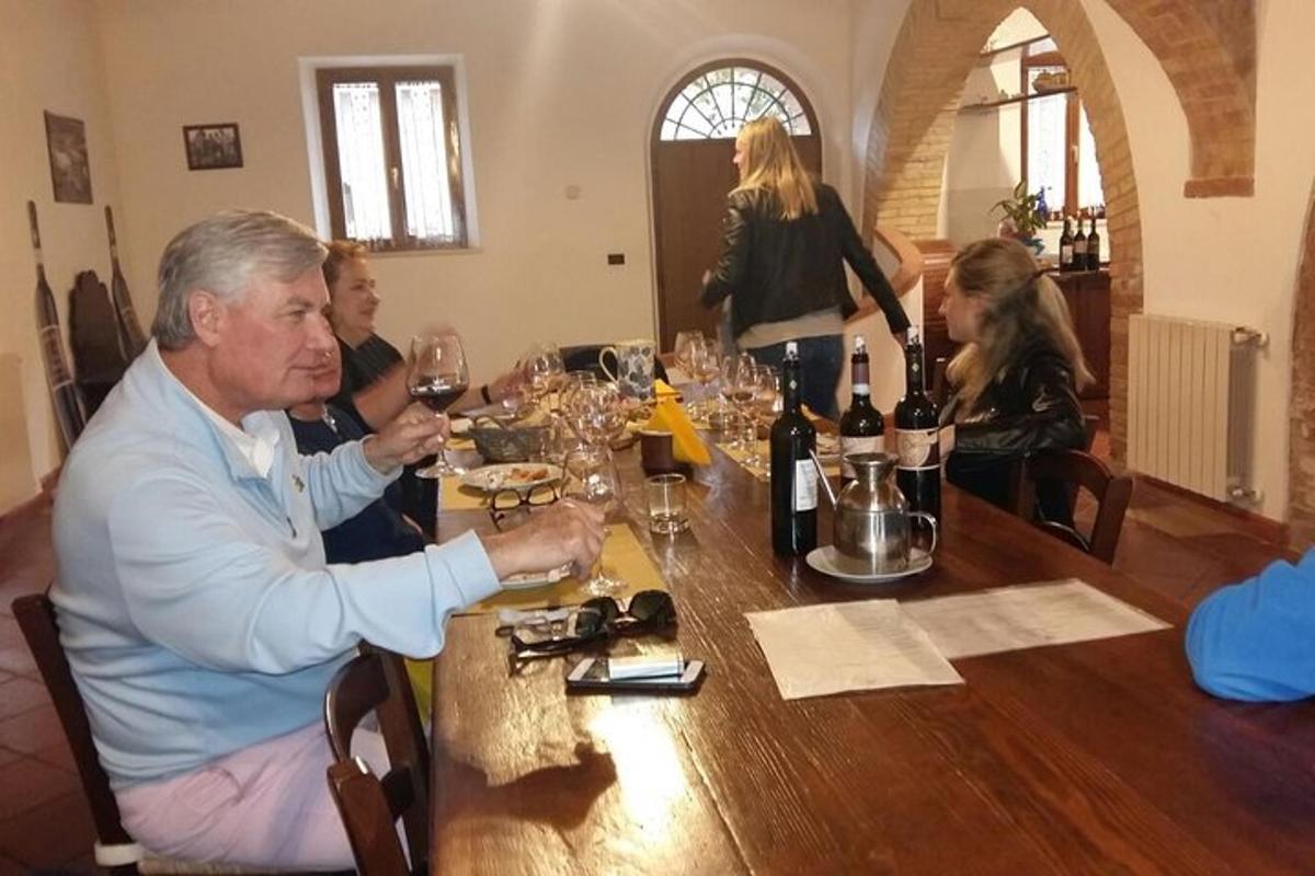 un gruppo di persone sedute attorno a un tavolo con bicchieri di vino