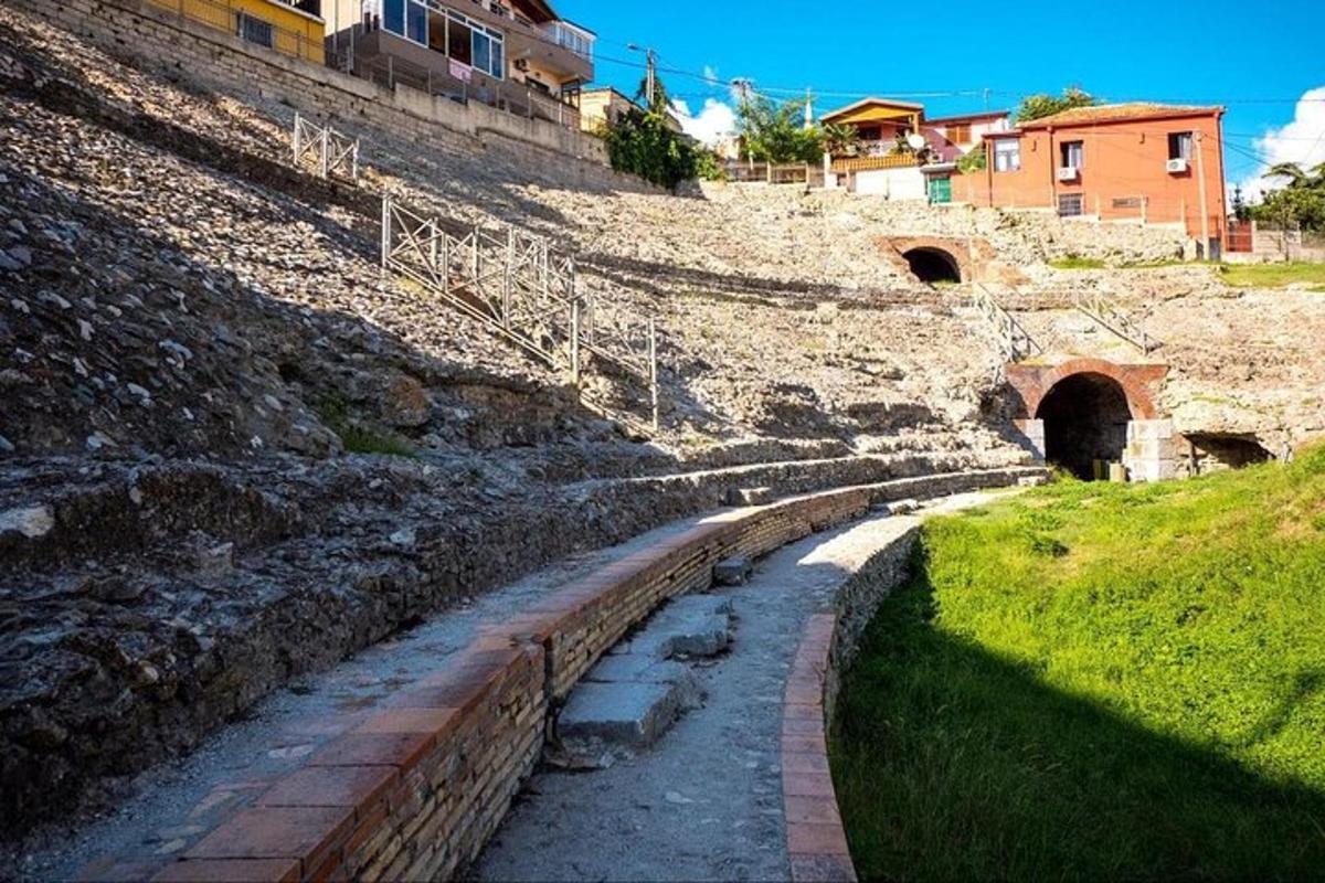 a stone wall next to a hill with a tunnel