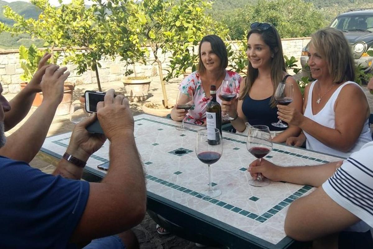 μια ομάδα ανθρώπων που κάθονται γύρω από ένα τραπέζι με ποτήρια κρασιού
