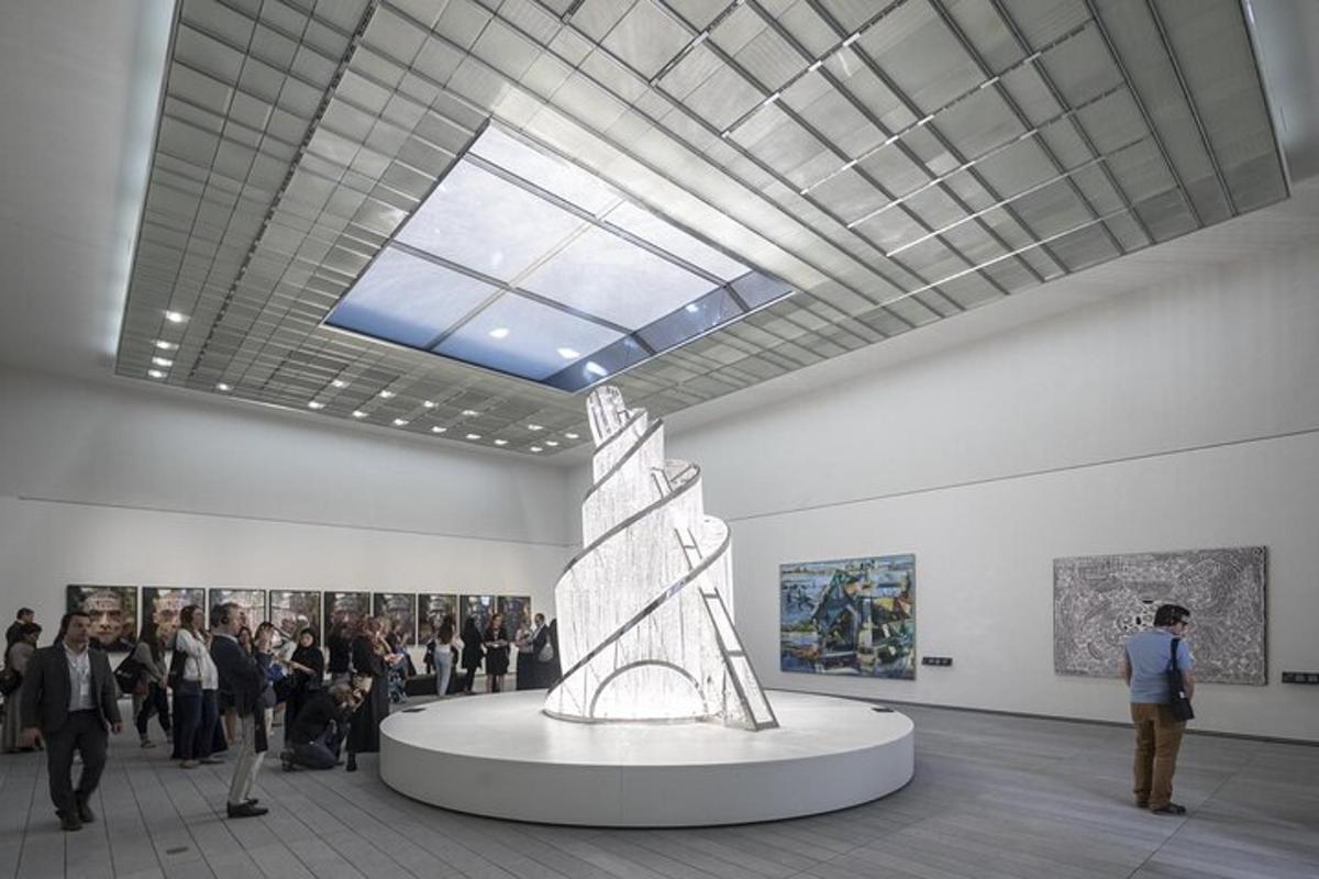 a crowd of people walking around an art exhibit