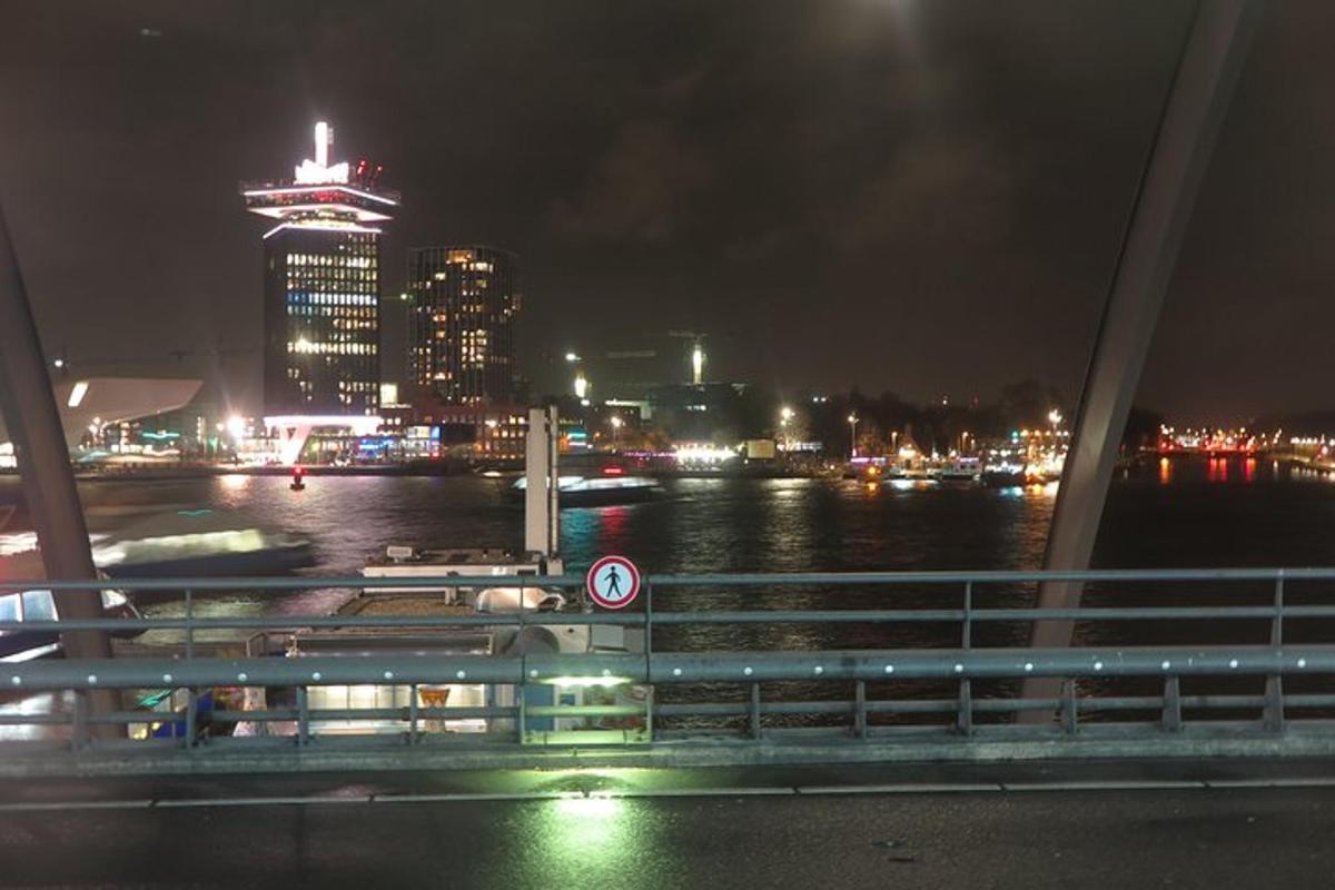 un ponte sopra un fiume con una città di notte