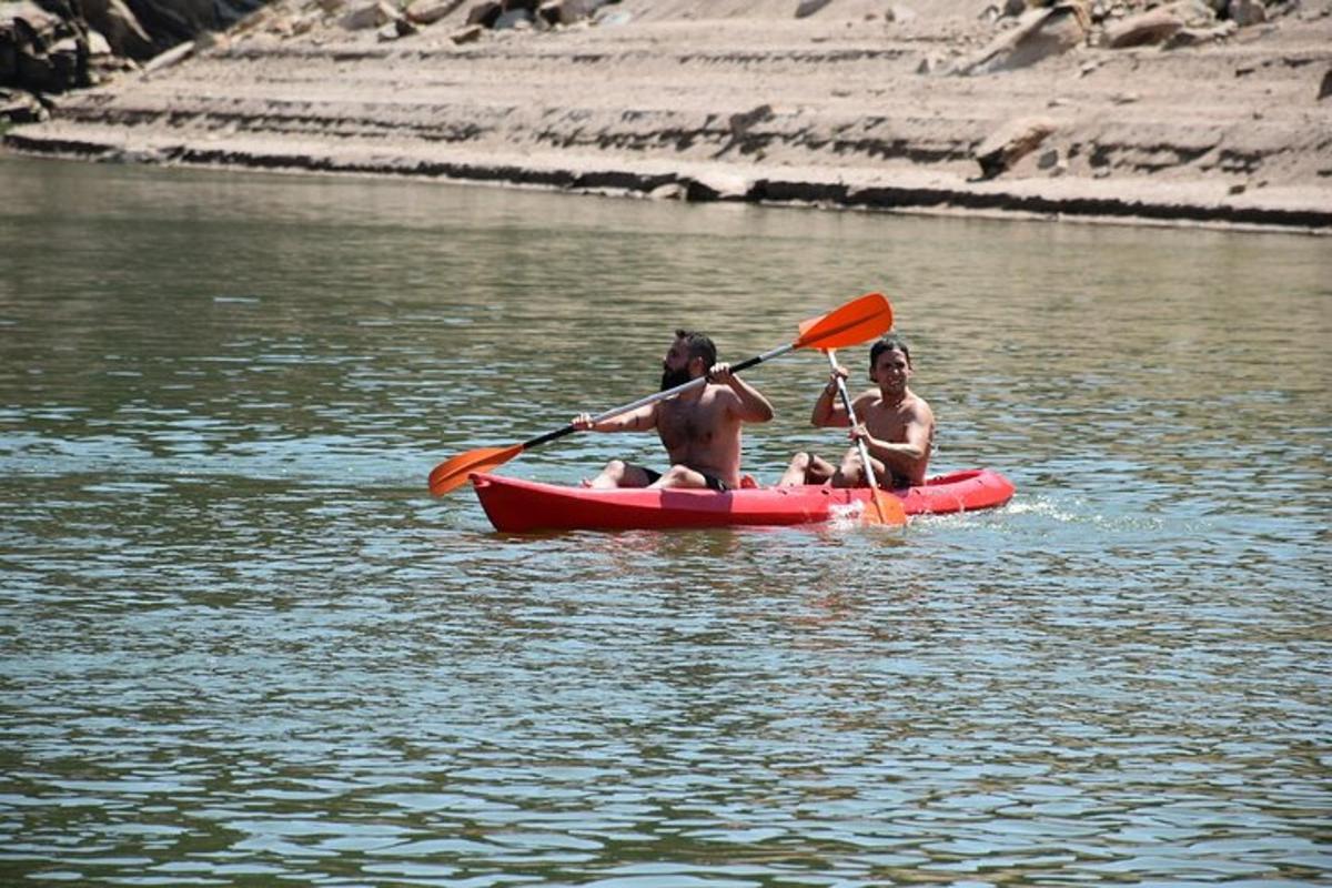 dua orang dalam kayak merah di sungai