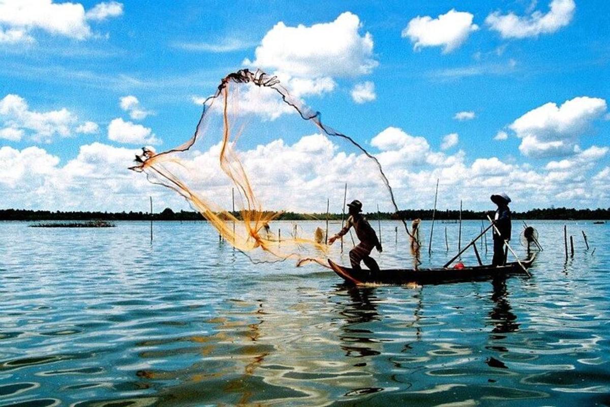 dua orang di atas bot dengan pukat di dalam air