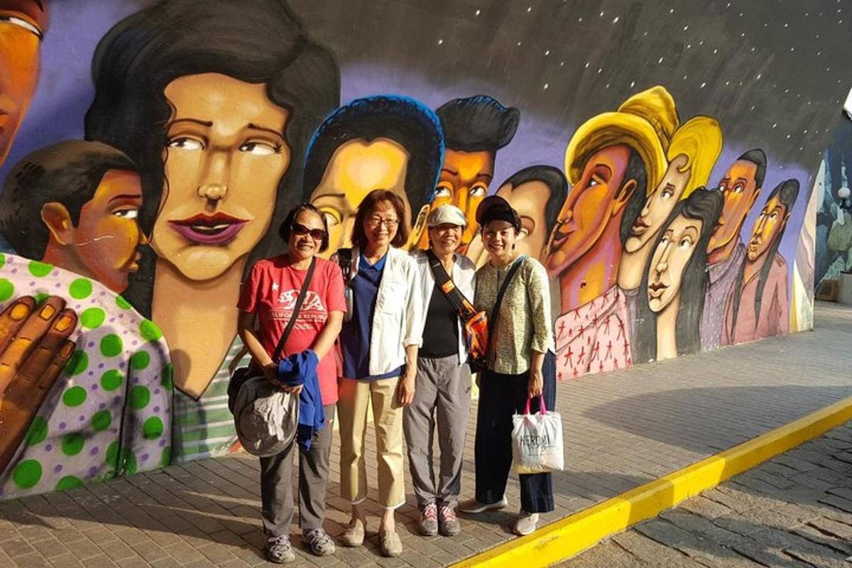 sekumpulan orang berdiri di hadapan mural