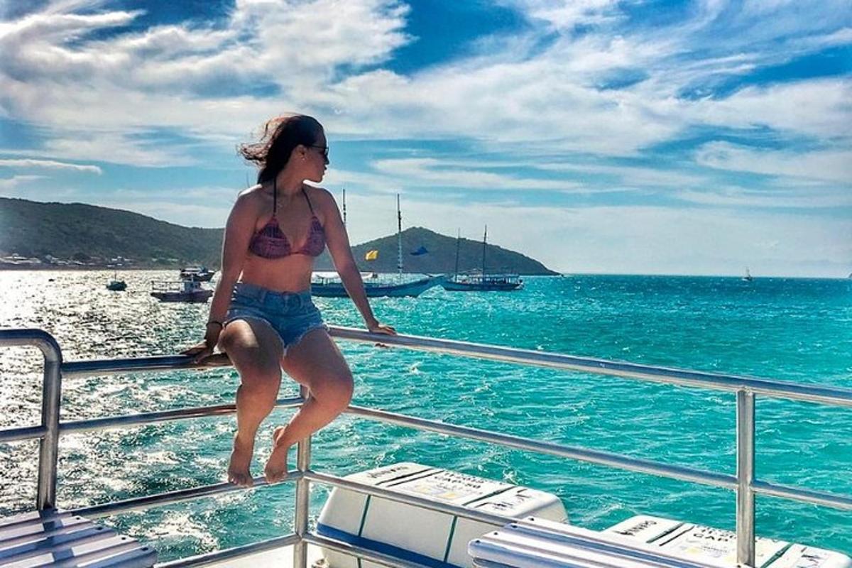 uma mulher de biquíni sentada na lateral de um barco