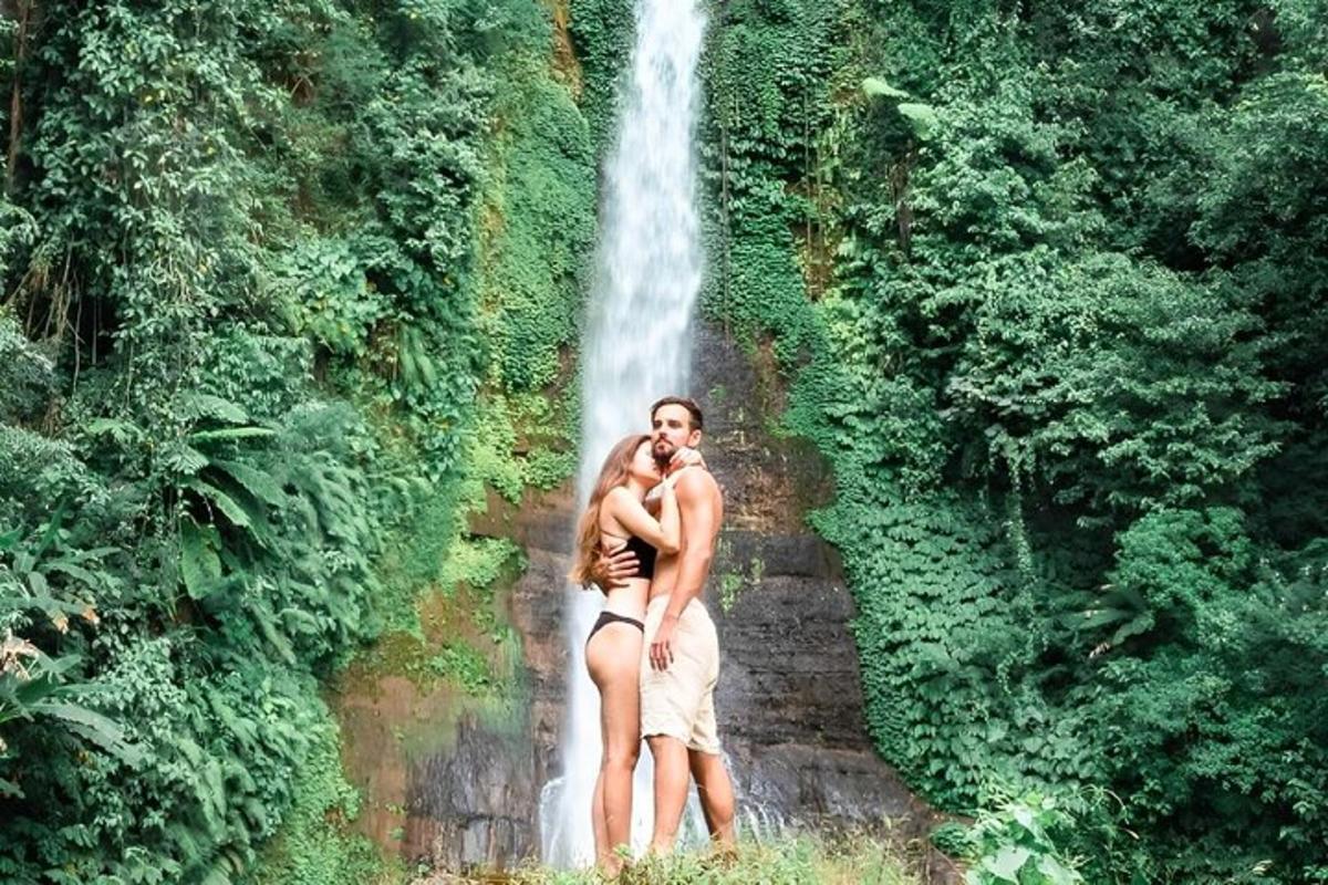Un hombre y una mujer de pie frente a una cascada