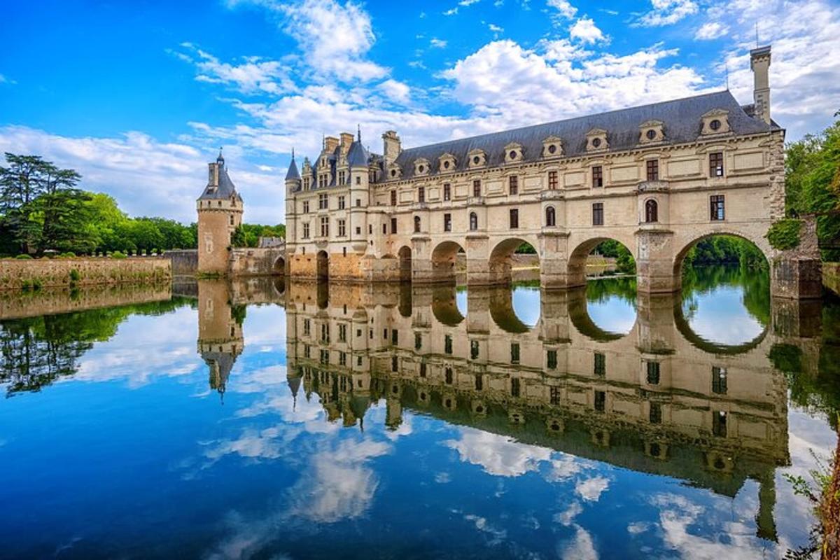 a castle reflected in the water in front of a bridge