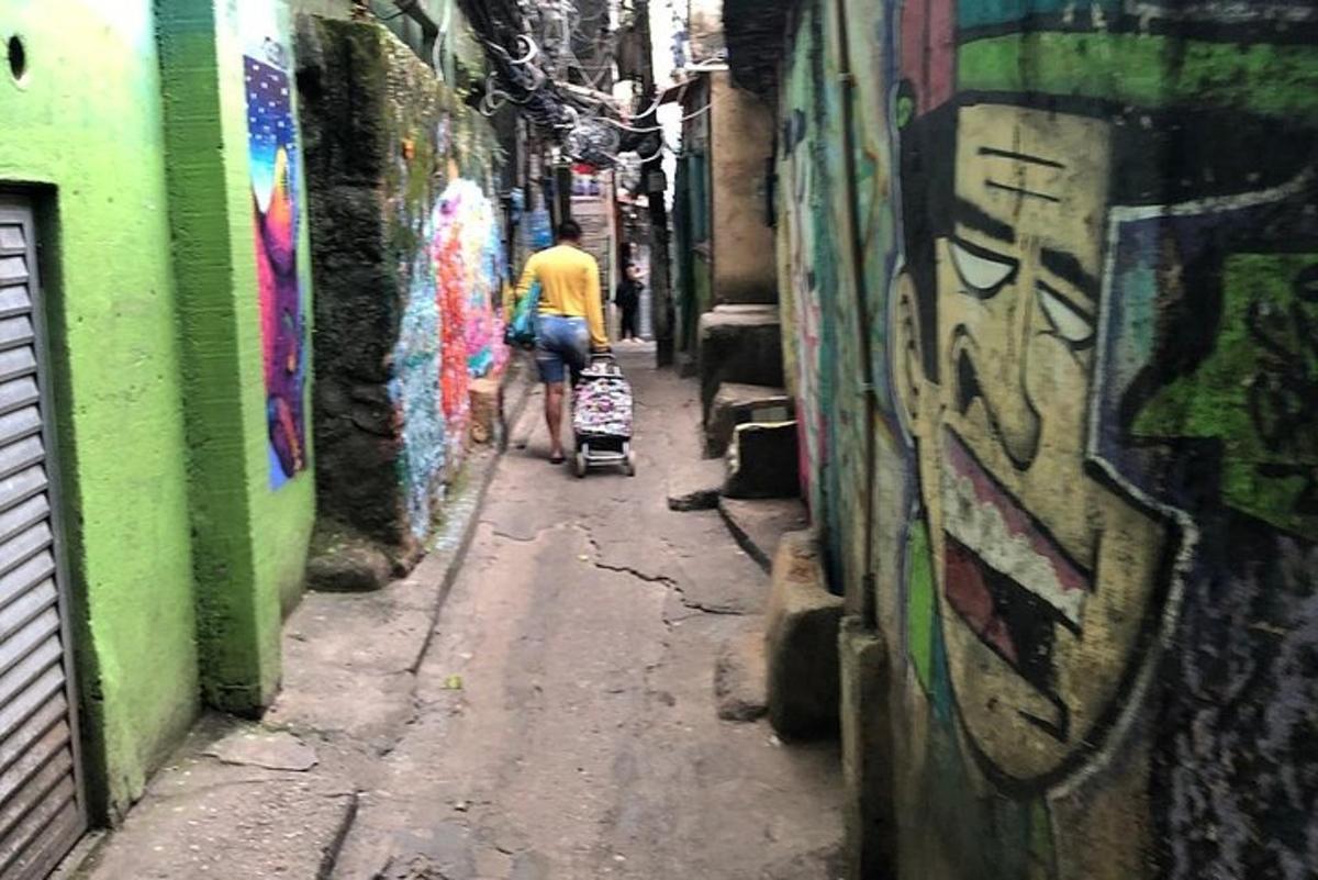 ein Mann schiebt einen Kinderwagen eine Gasse mit Graffiti entlang