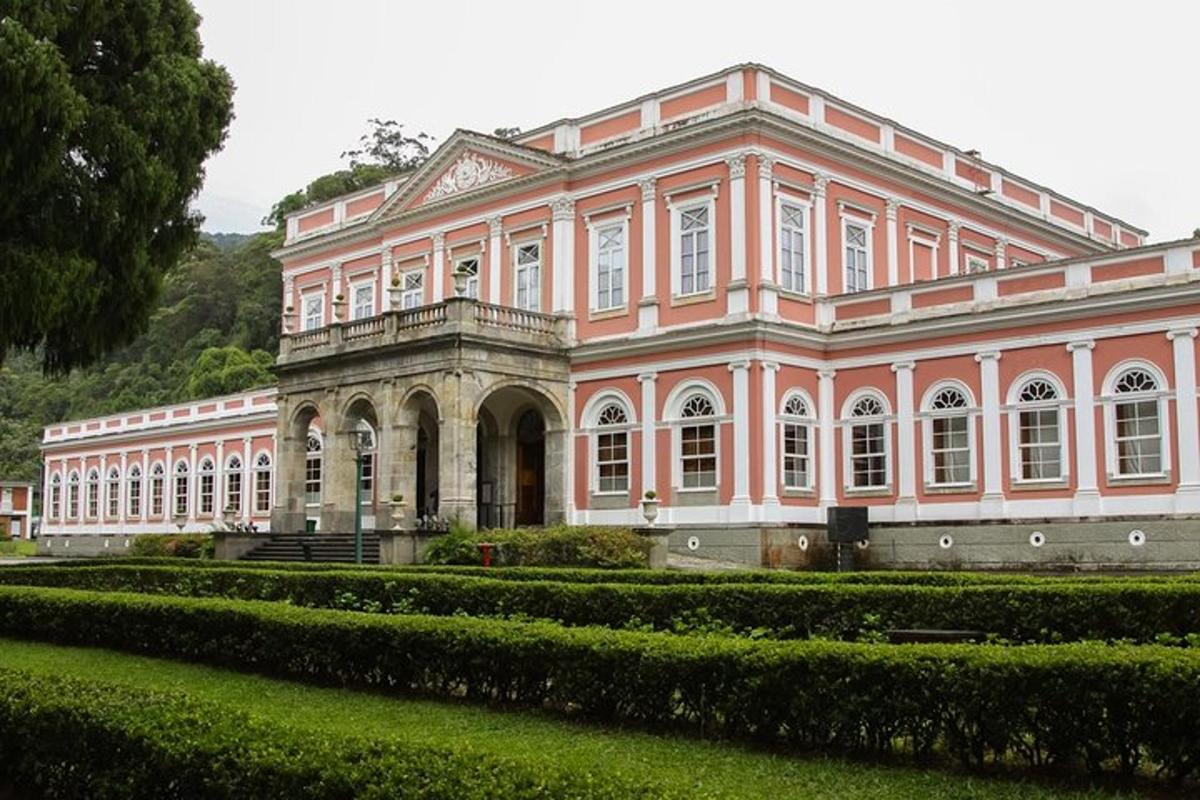velika rožnata stavba z vrtom pred njo