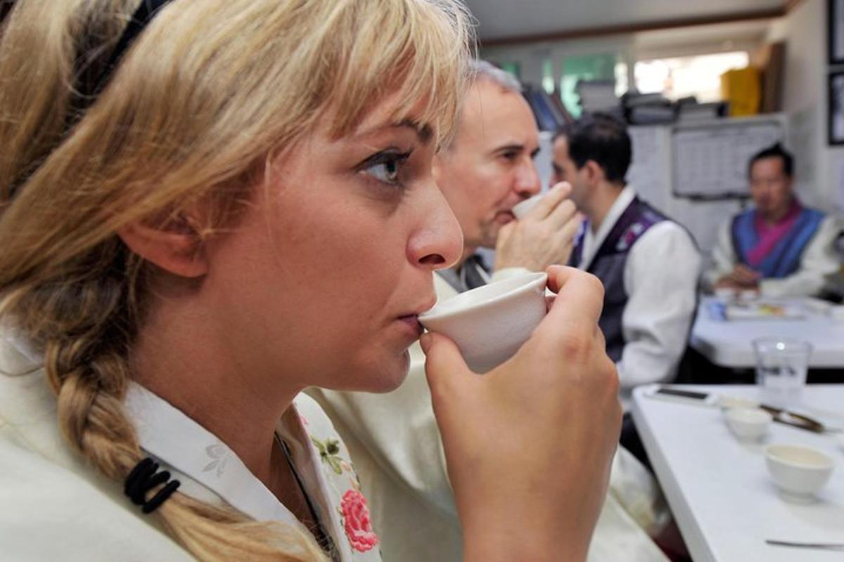 žena pije z hrnku v restauraci