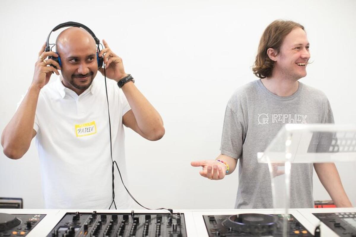 two men standing next to a table with headphones