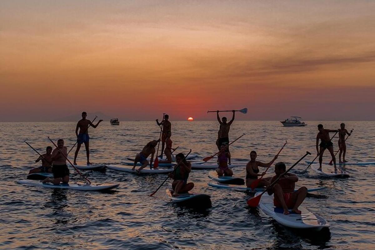 a group of people on kayaks in the water at sunset