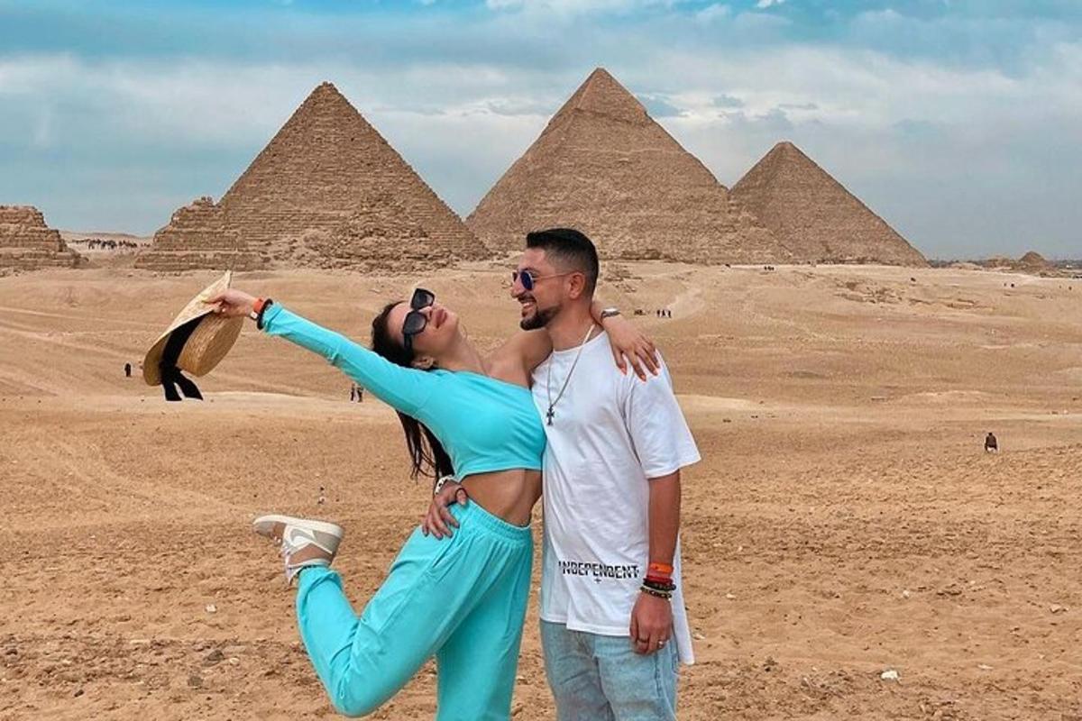 un uomo e una donna in posa davanti alle piramidi