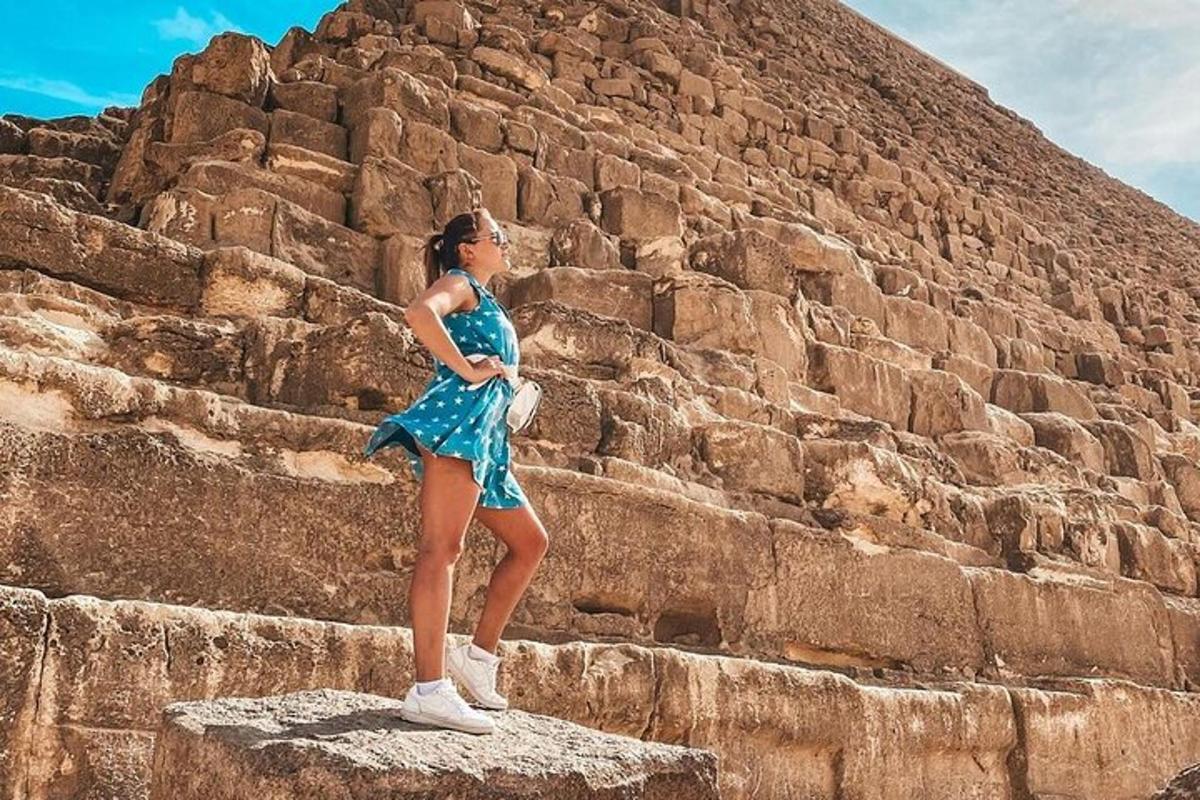 uma mulher de vestido azul em pé sobre uma rocha