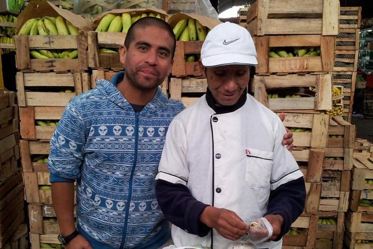 due uomini in piedi uno accanto all'altro davanti alle banane