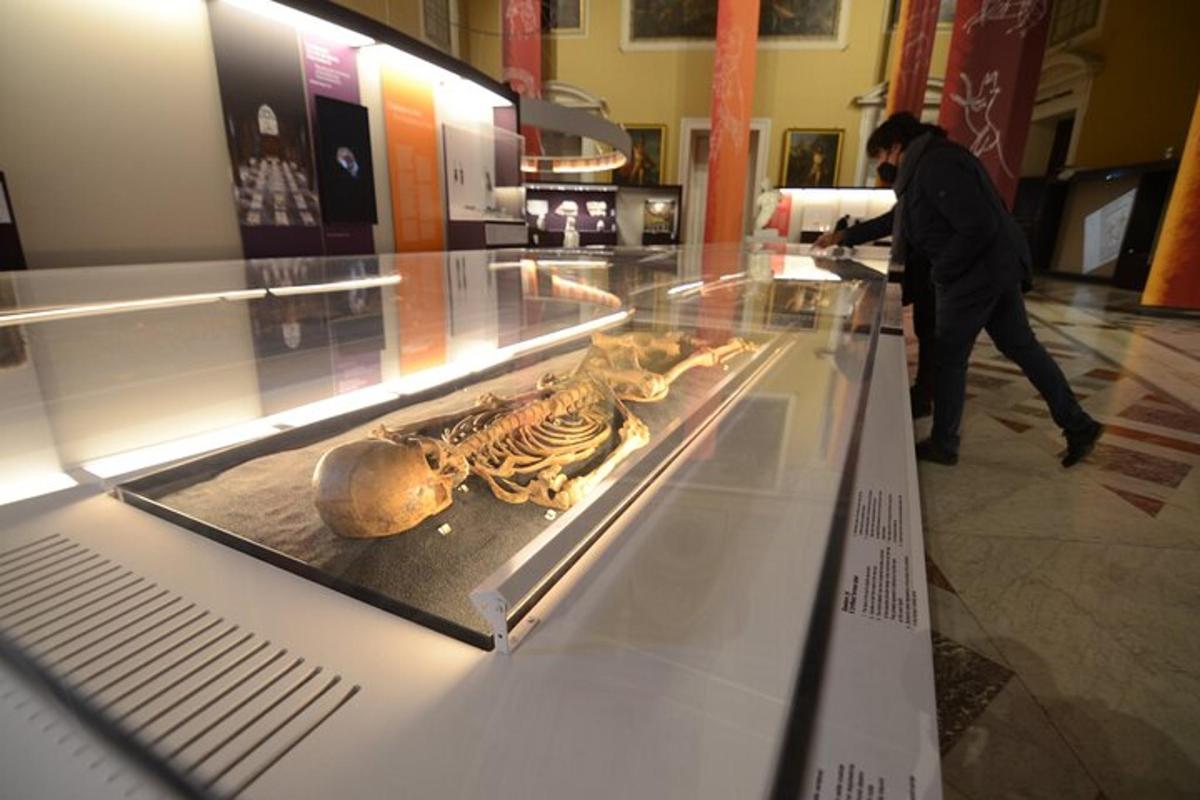 seorang pria berjalan melewati etalase di museum
