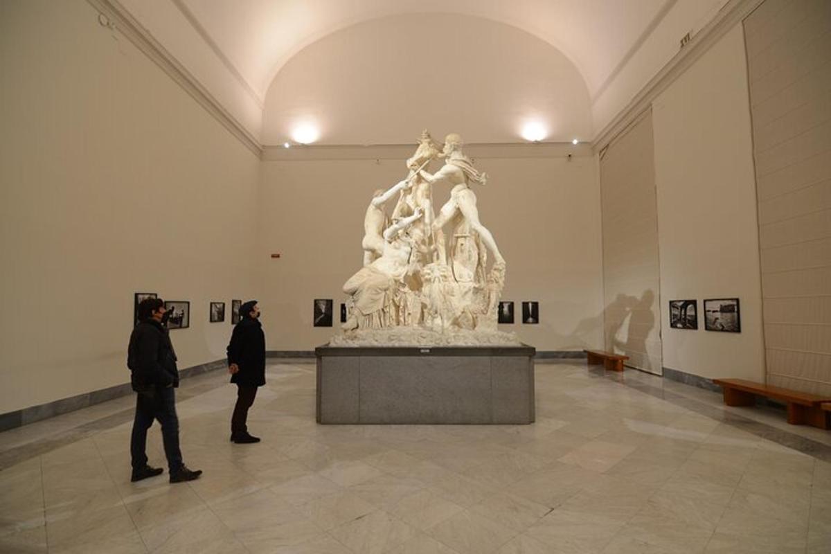 dua orang berdiri di museum seni sambil melihat patung