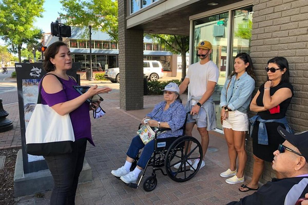 Un grupo de personas de pie alrededor de una mujer en silla de ruedas.