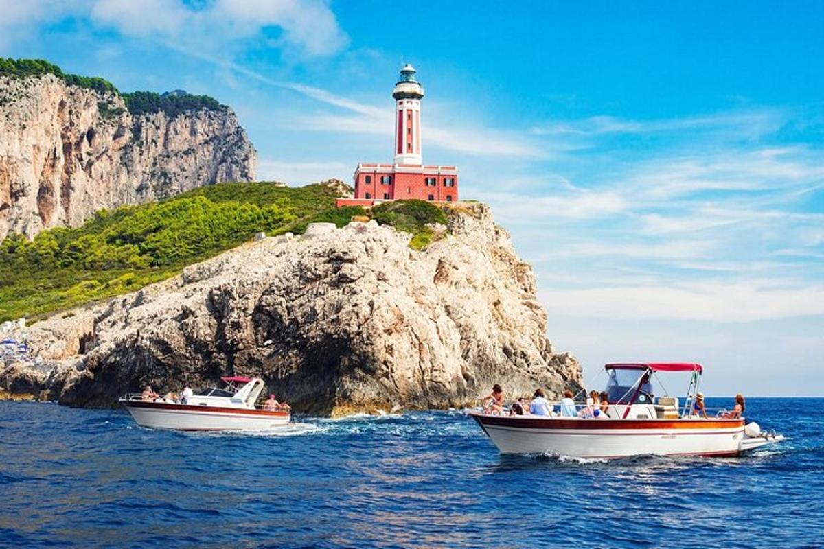due barche in acqua davanti a un faro