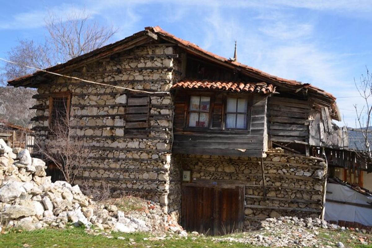 Una antigua casa de piedra con una ventana en una colina.