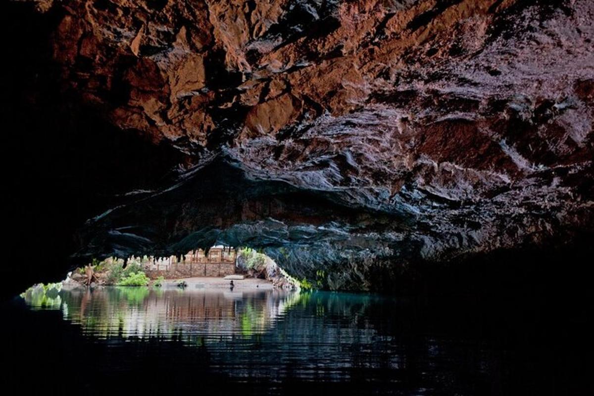 una cova amb una massa d'aigua al costat d'un penya-segat
